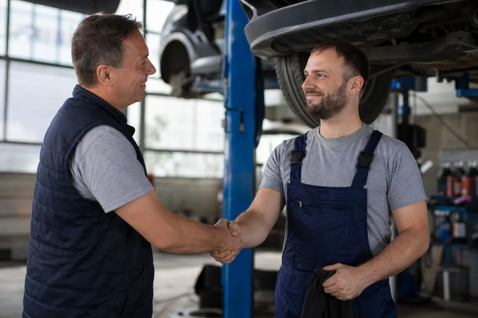 Kierownik warsztatu wita nowo zatrudnionego mechanika